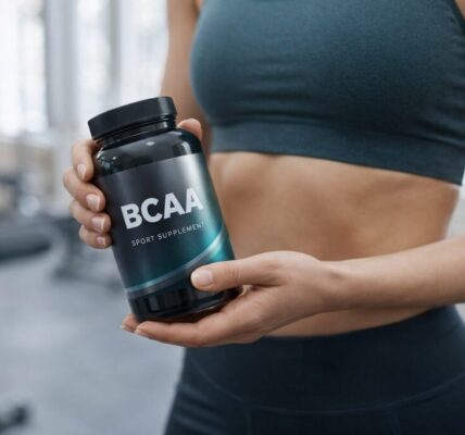 Kobieta w stroju sportowym ogląda odżywki dla sportowców - w dłoniach ma BCAA